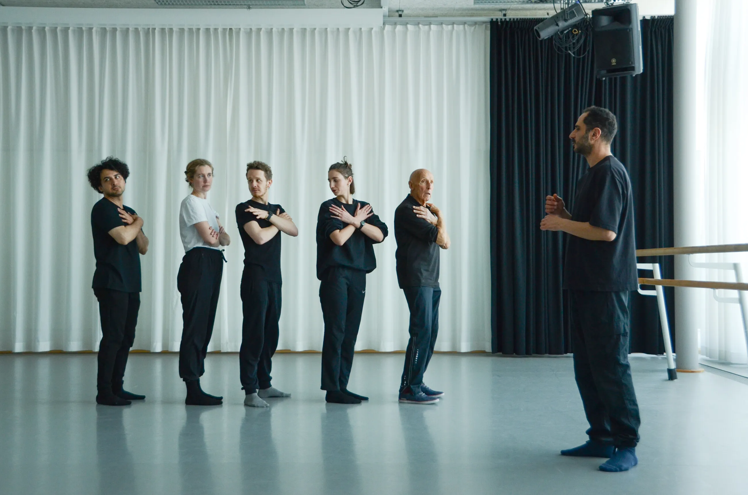 Ensemble von Après Theater steht während einer Probe im Gespräch mit dem Regisseur.